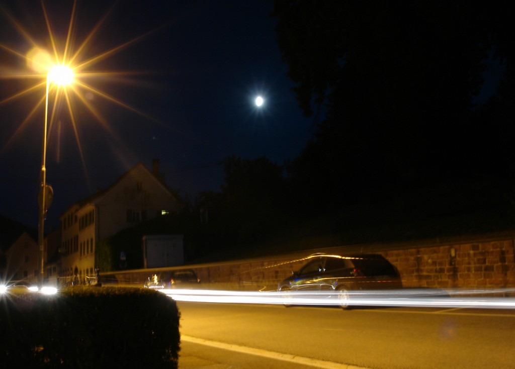 Mond und Straßenlaterne nachts in Langzeitbelichtung