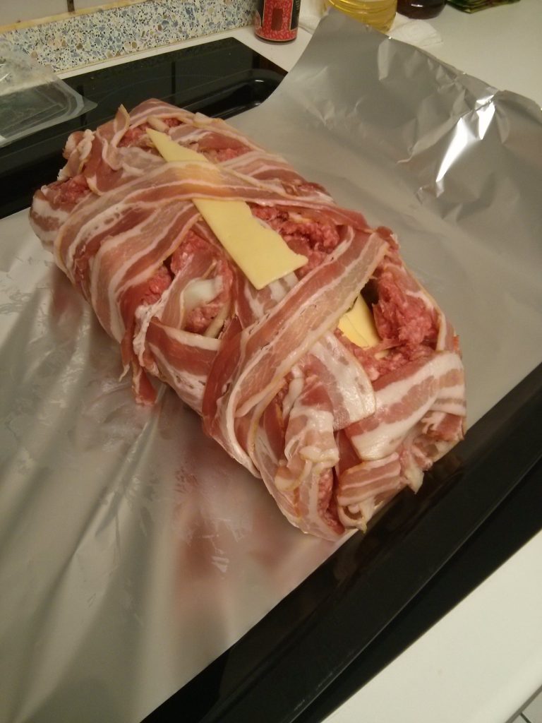 Hackfleisch in einem Netz von Baconstreifen