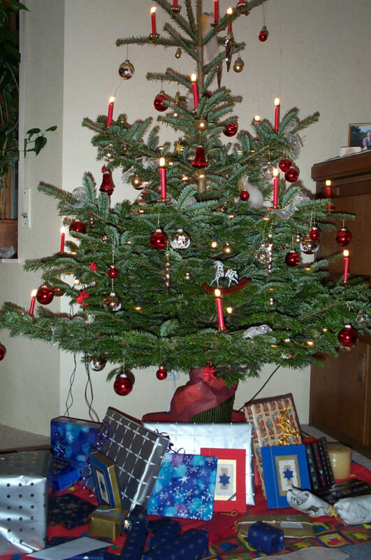 Geschmückter Weihnachtsbaum mit roten Kerzen und roten und goldenen Glaskugeln