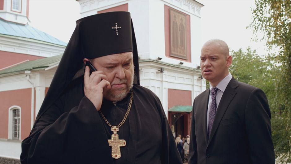 Priester mit Handy und Außenminister