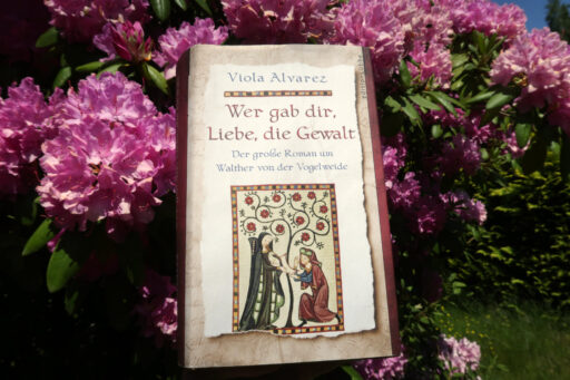 Buch vor einem blühenden Rhododendron-Busch