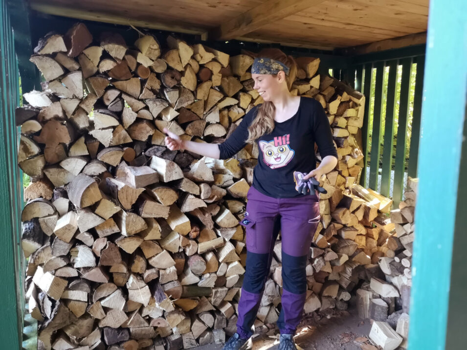 Foto von Lucyda vor einem Holzstapel