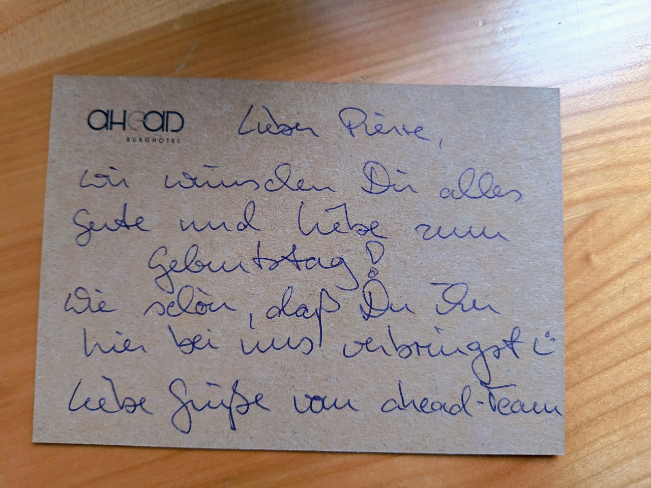 Rückseite der Karte aus Umweltpapier. Mit Kuli steht dort geschrieben: "Lieber Pierre, wir wünschen Dir alles Gute und Liebe zum Geburtstag! Wie schön, daß Du ihn hier bei uns verbringst :) Liebe Grüße vom ahead-Team"